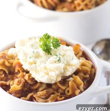A savory lasagna soup recipe served in two white bowls.