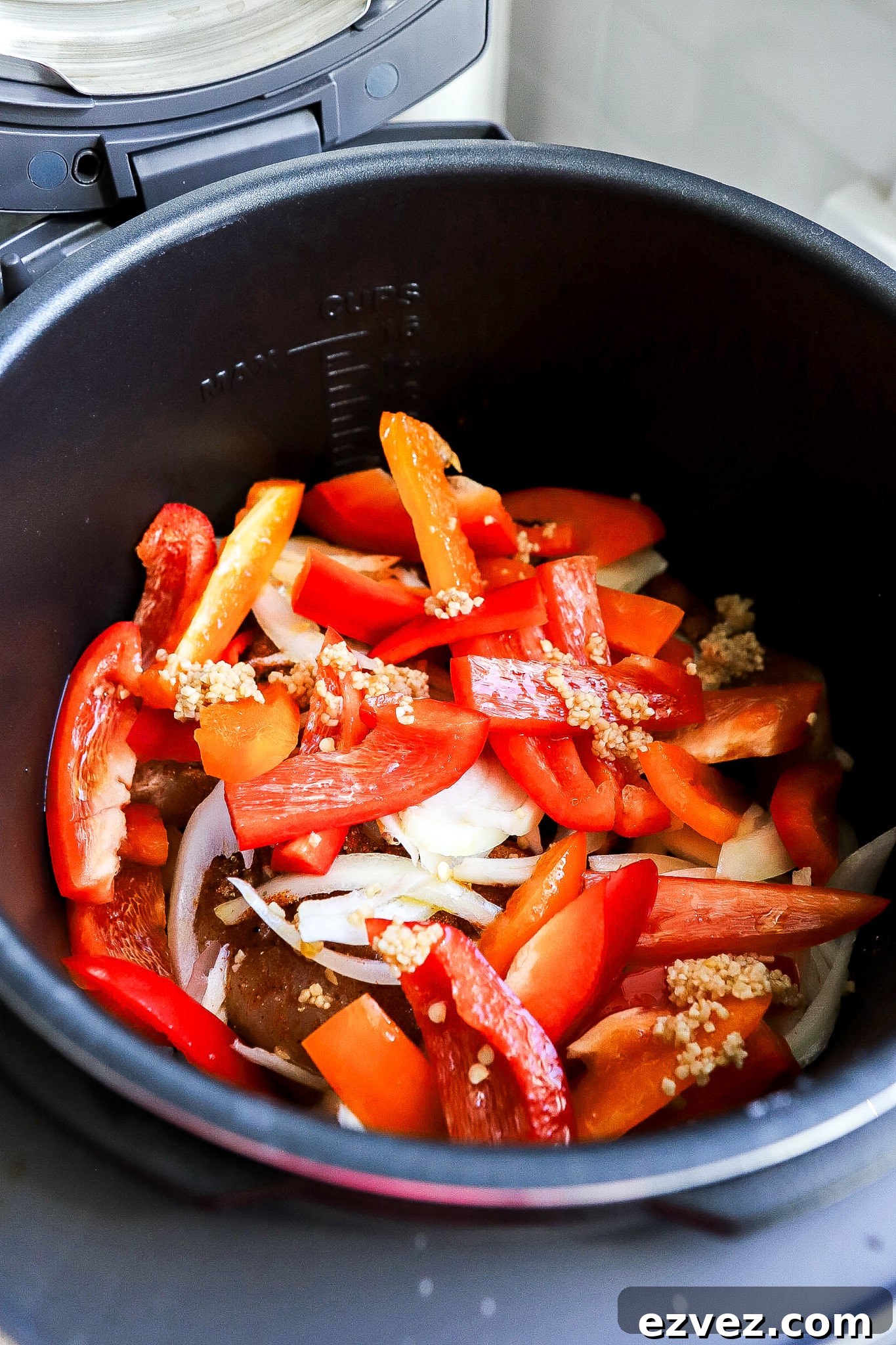 Side angle of a crockpot filled with chicken and bell peppers.