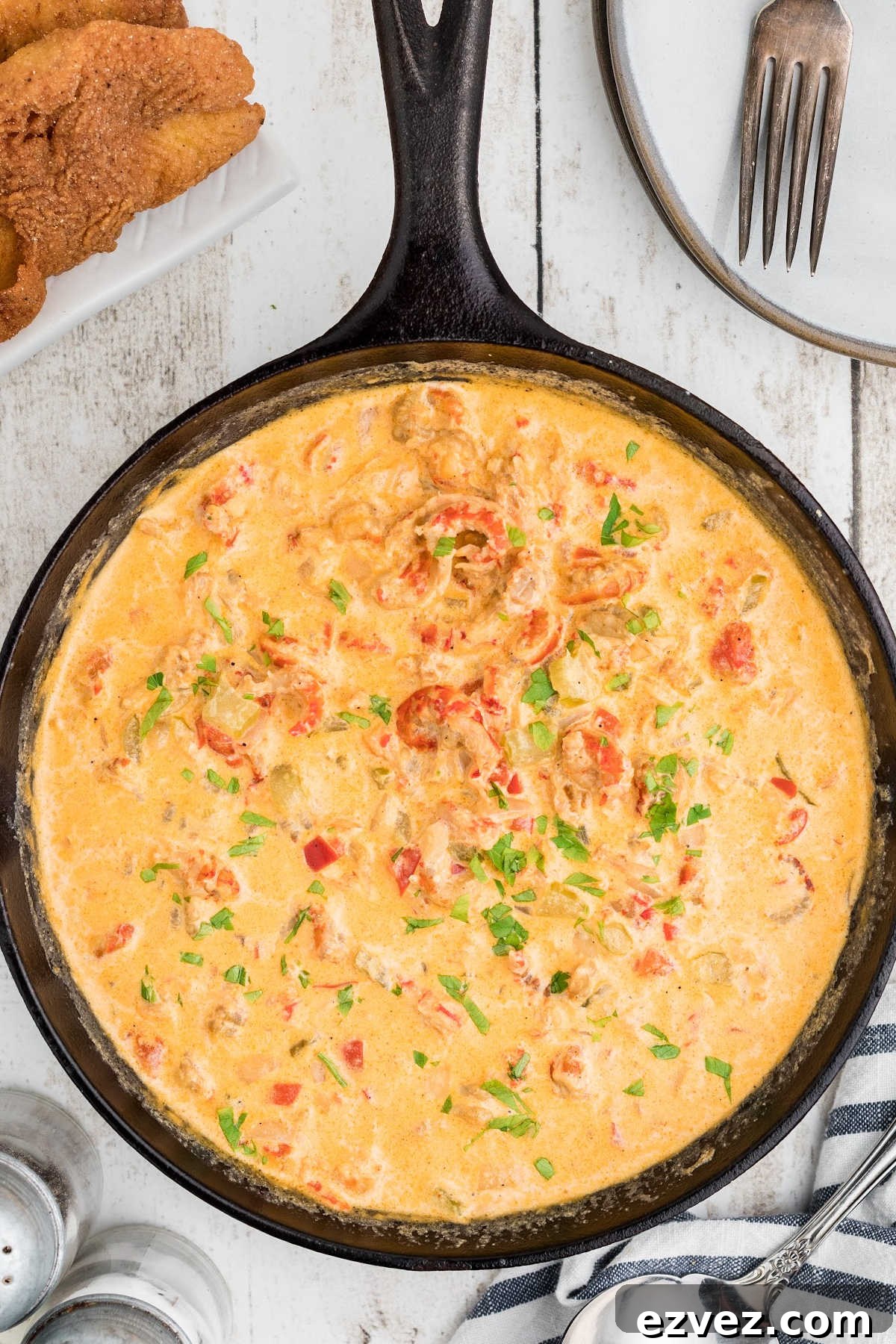 A close up overhead view of a cast iron skillet full of crawfish sauce.