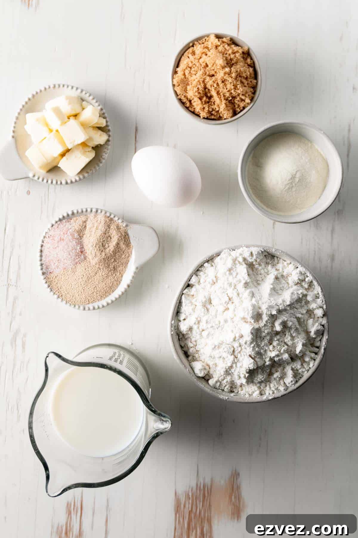 Ingredients for the rolls measured out in bowls and measuring cups. The butter is cubed.