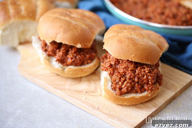 15-Minute One-Pot Sloppy Joes Recipe 4 Two sloppy joe sandwiches on a wooden cutting board.