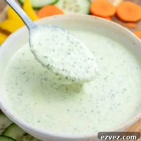 a spoon full of green goddess dressing from a bowl.
