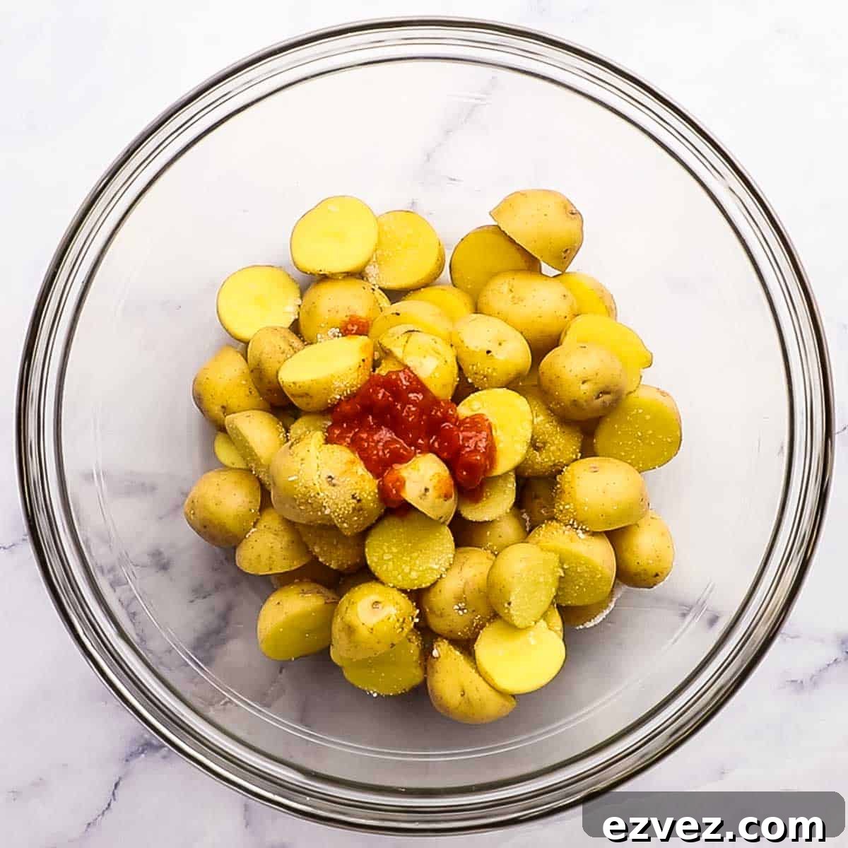 baby potatoes in a bowl with salt, harissa paste, and olive oil
