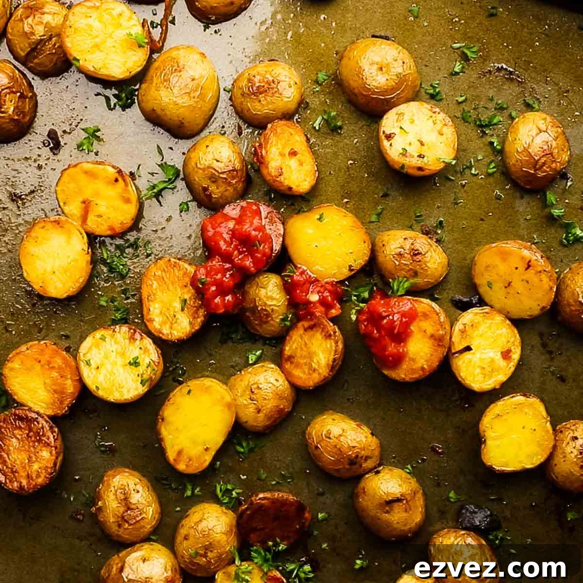 adding harissa paste and lemon juice on the roasted potatoes