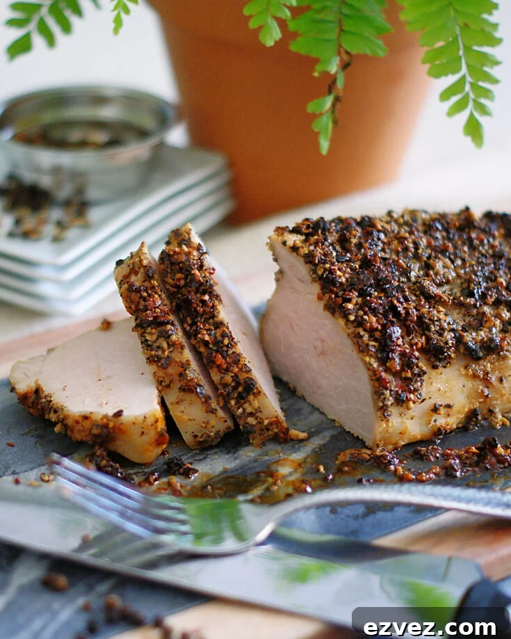 Pepper Crusted Pork Tenderloin, sliced and on a cutting board.