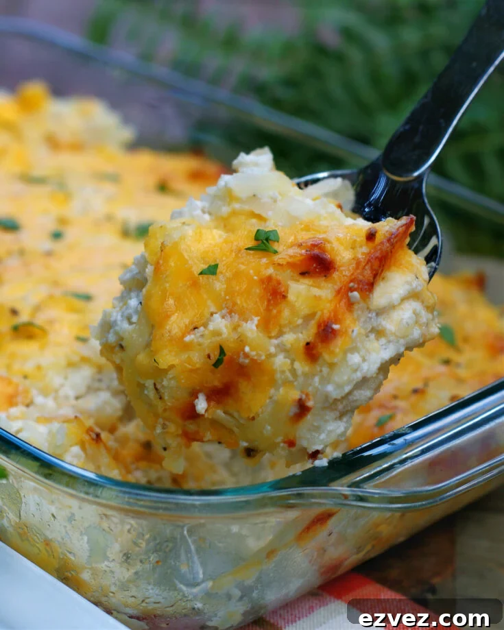 A serving of Cheesy Hashbrown Casserole in a spoon