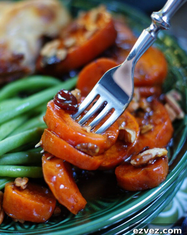 Stovetop candied sweet potatoes on a fork to show tenderness and texture after cooking.