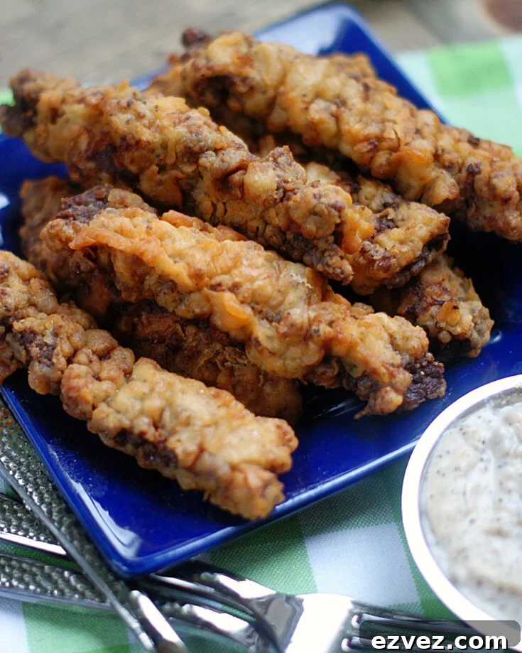 A blue plate piled high with Chicken Fried Steak Fingers.