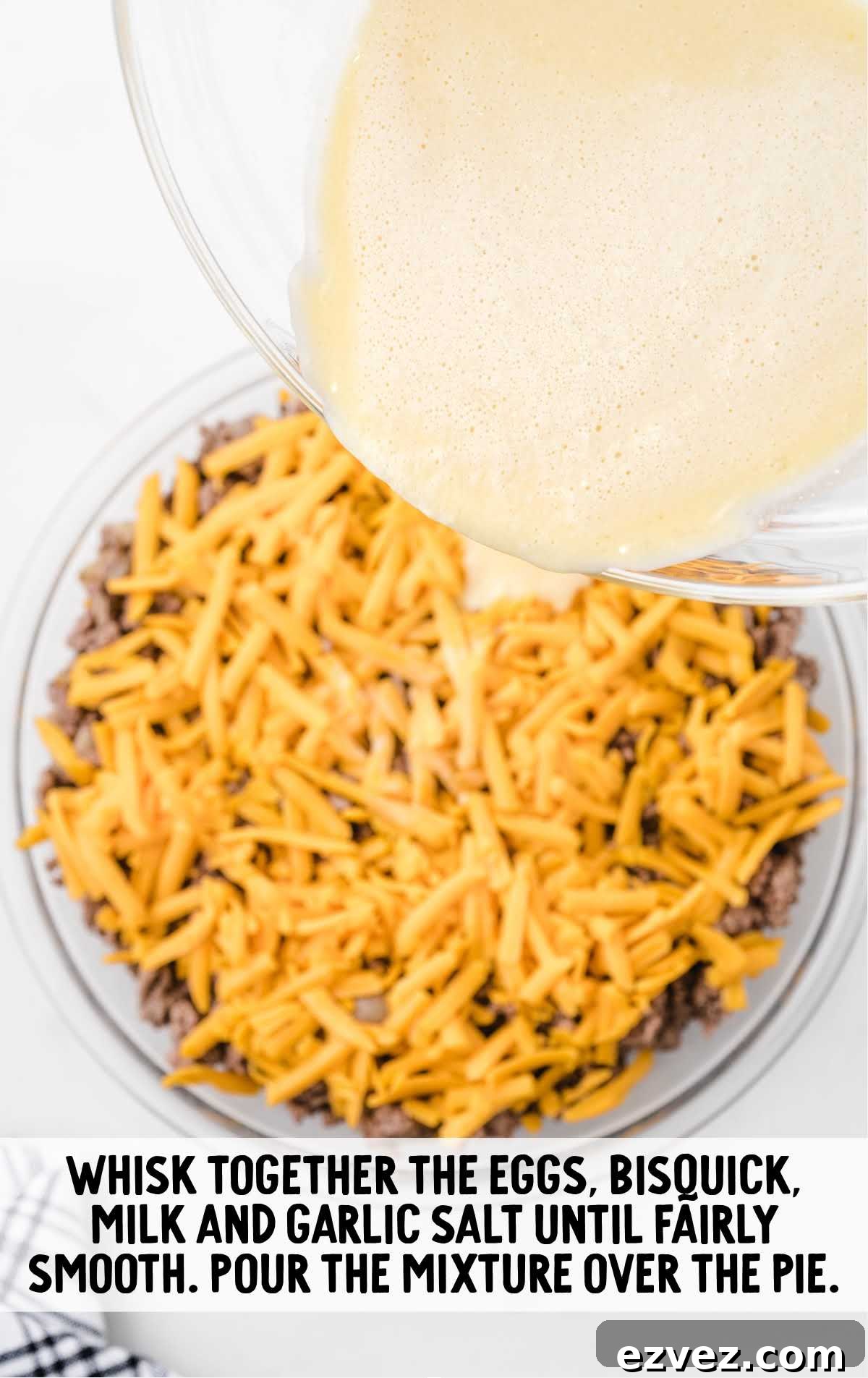 batter mixture poured on top of the cheddar cheese in the baking dish