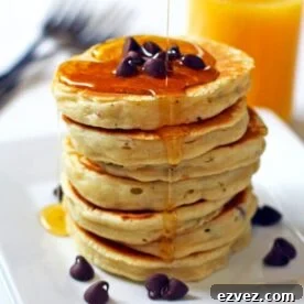 A stack of chocolate chip pancakes with maple syrup