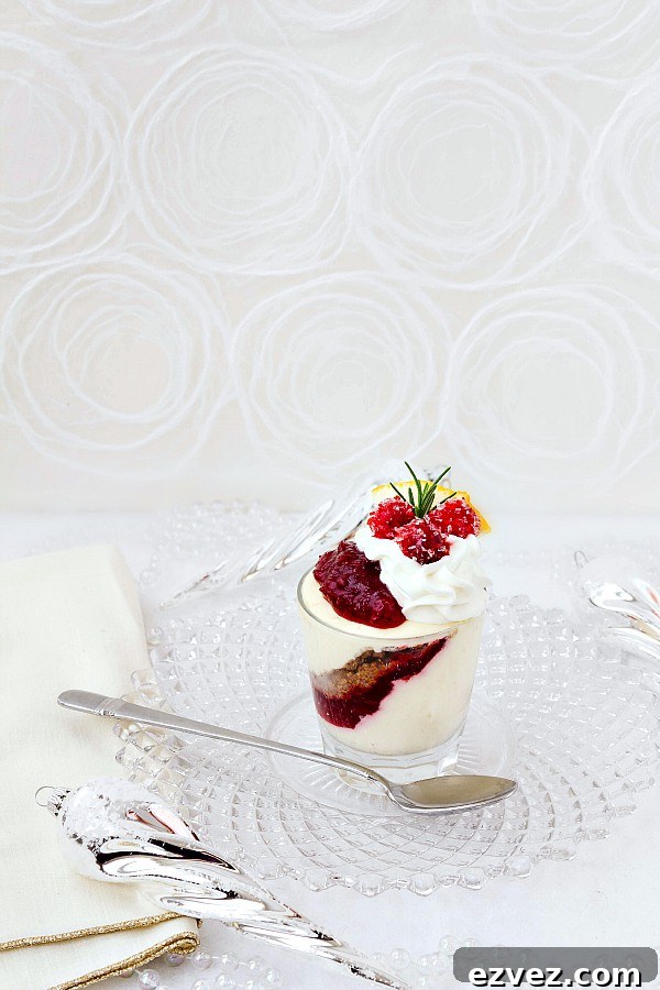 One no-bake orange cranberry cheesecake parfaits ready to serve on a clear glass plate with silver spoon.