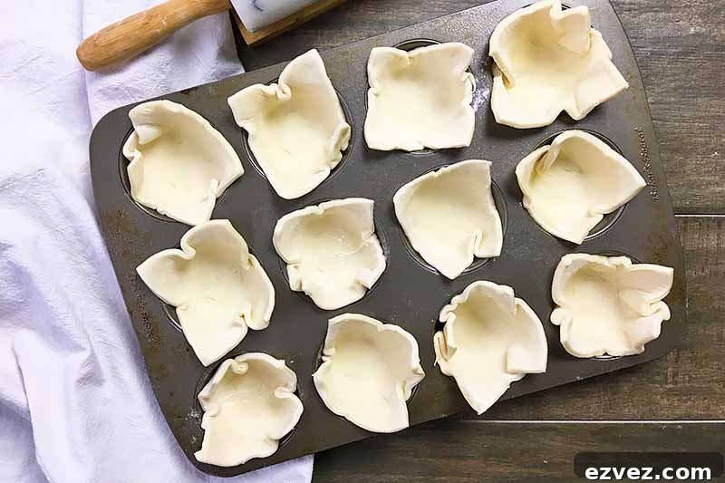 Horizontal image of dough lining muffin cups.