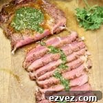 Grilled steak, partially sliced, topped with chimichurri sauce.