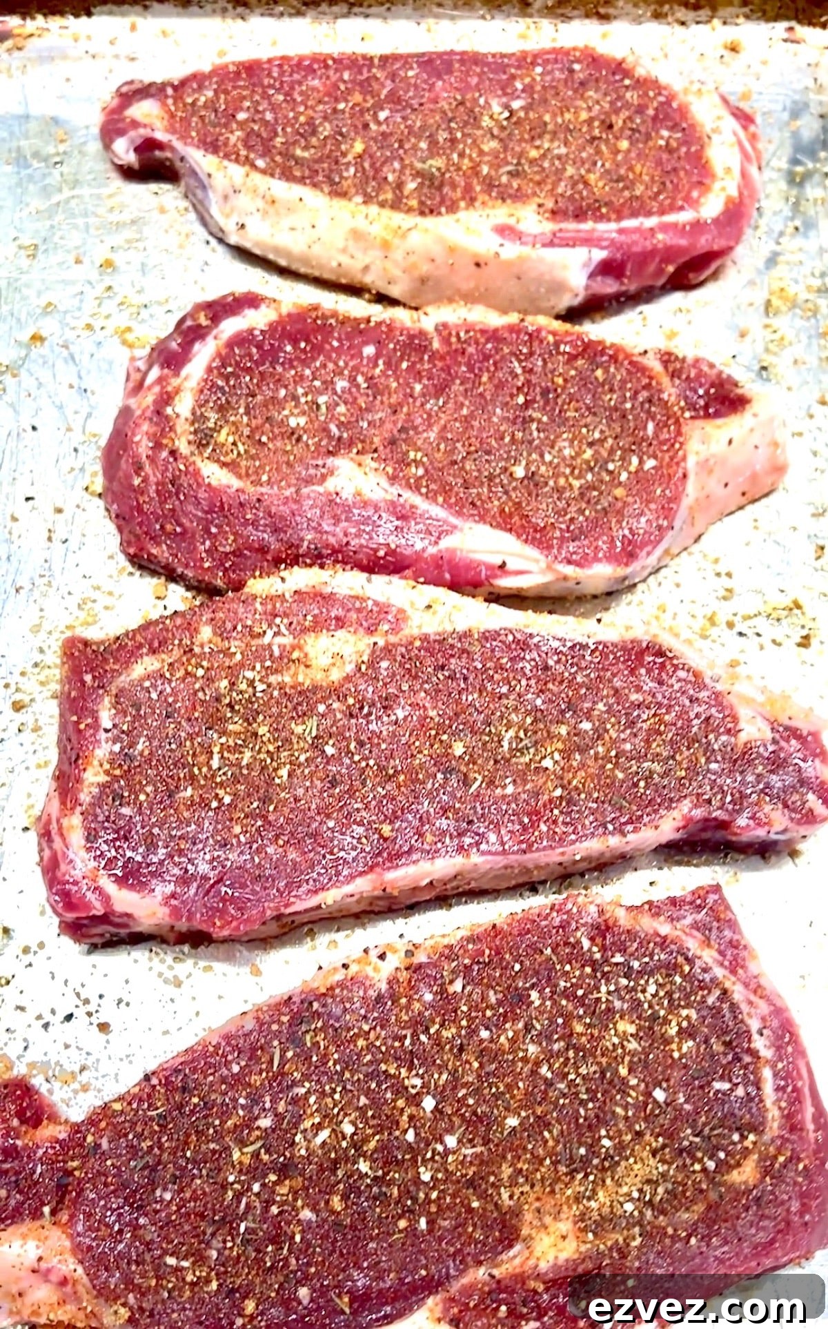 Seasoned ribeye steaks ready to grill.