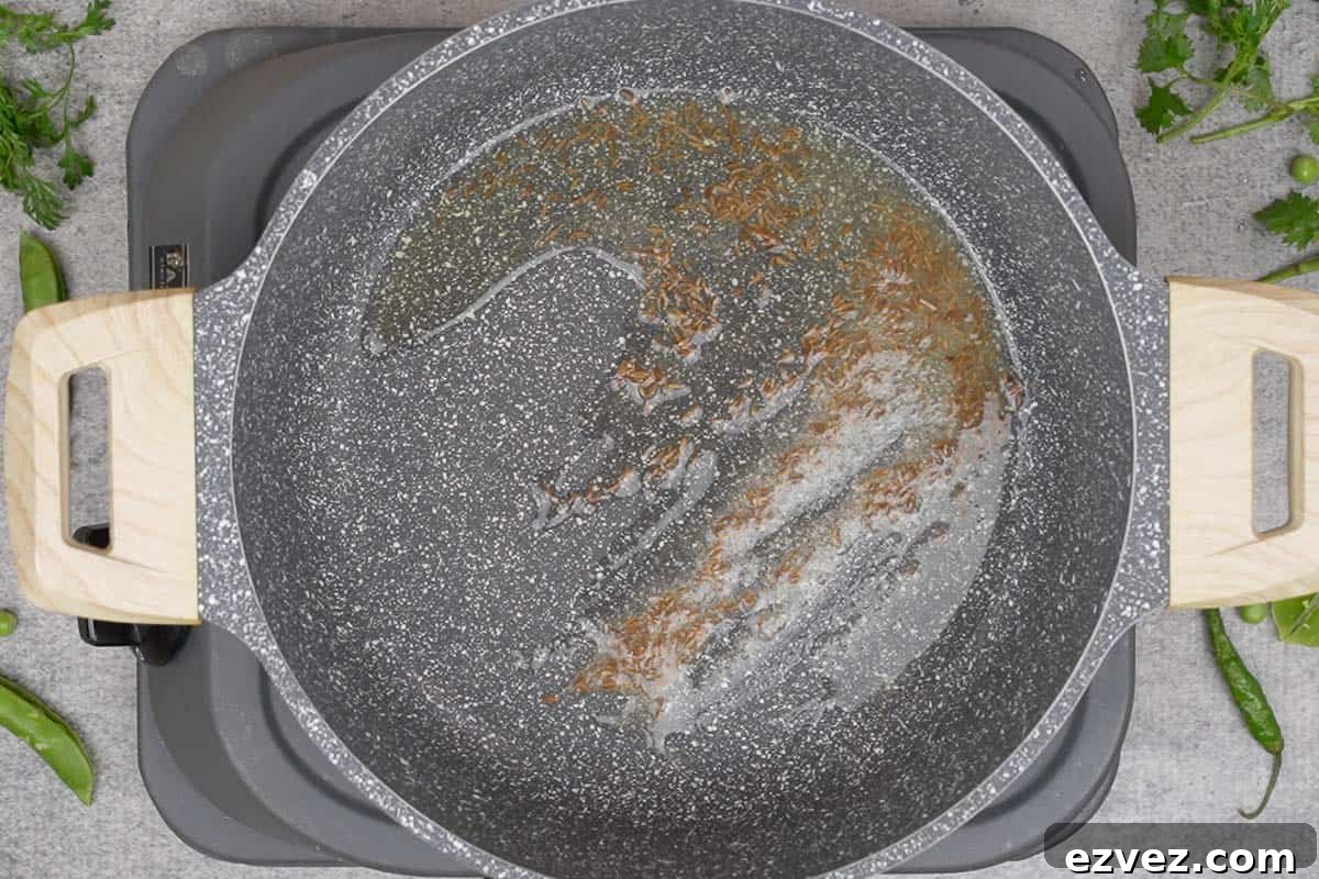Asafetida and cumin seeds crackling in a pan.
