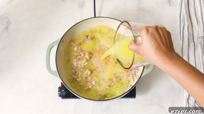 Broth in a pot with sauteed vegetables
