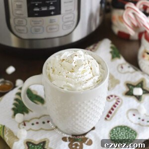cup of hot chocolate with whipped cream in front of an instant pot