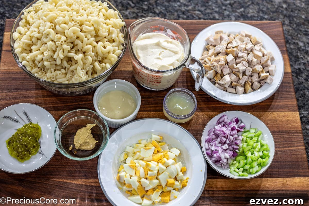 Creamy Chicken Macaroni Salad with Tangy Herb Dressing 4 Ingredients for macaroni salad laid out on a chopping board.