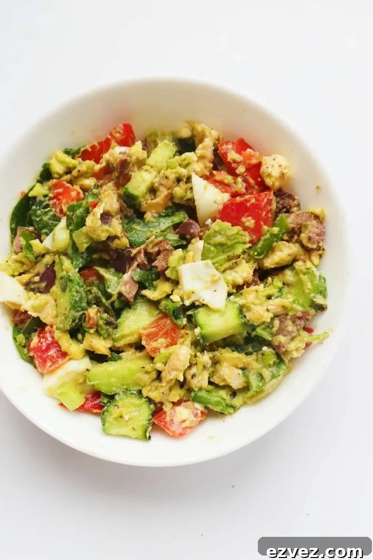 Fresh low carb avocado chicken salad with chopped vegetables, olives, chicken, egg, and creamy mashed avocado.