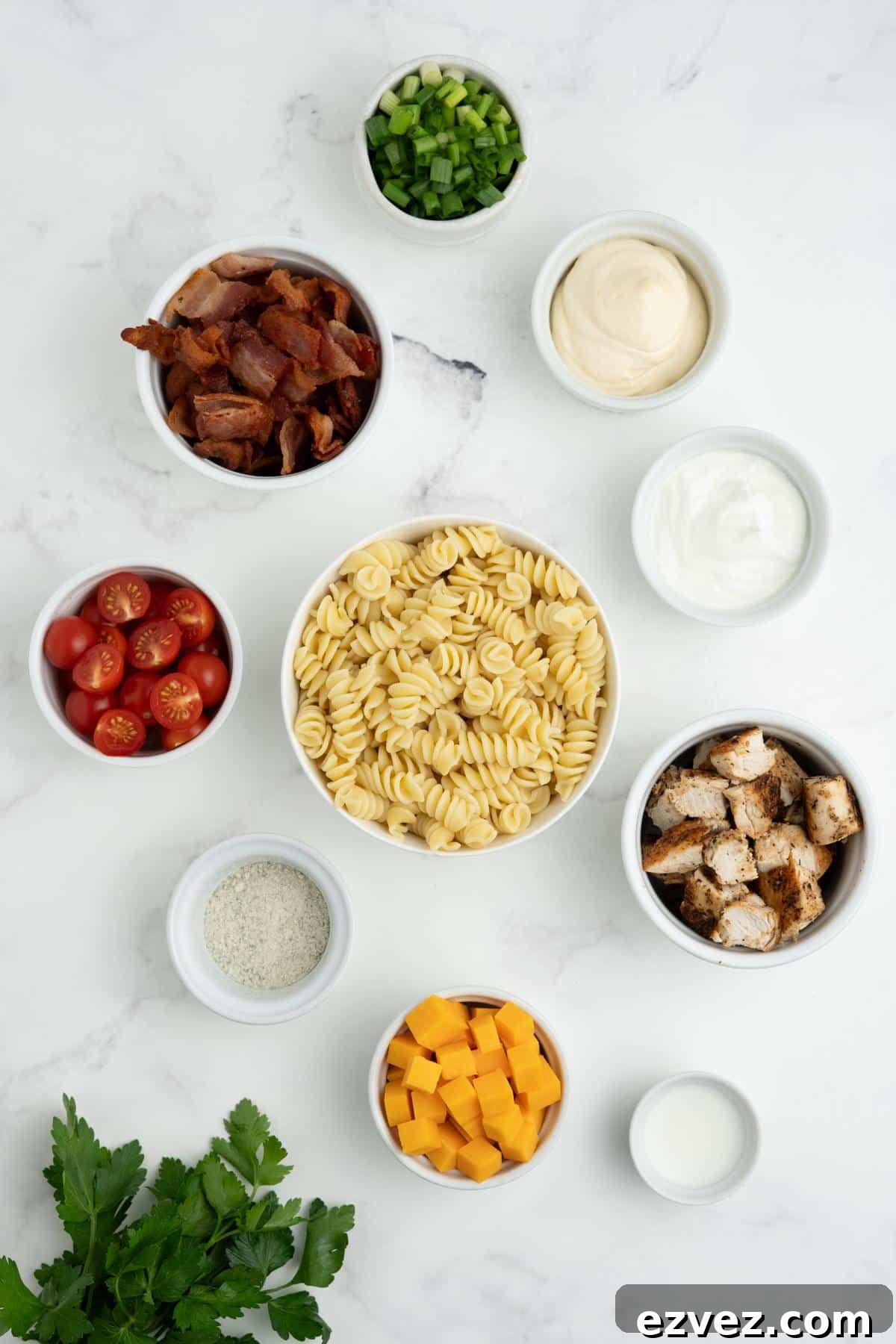Ingredients to make bacon ranch pasta salad on the table.