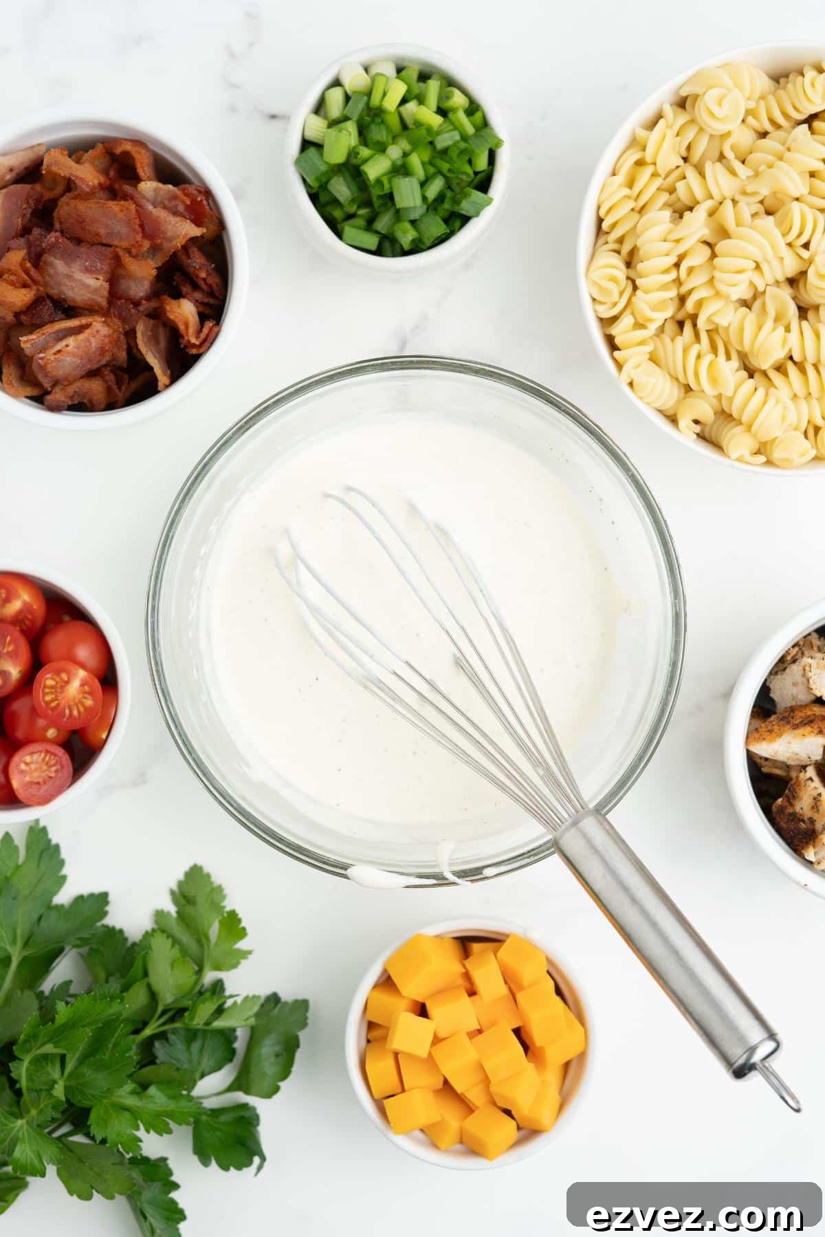 Mixing the ranch dressing in a bowl with a whisk resting on the side.
