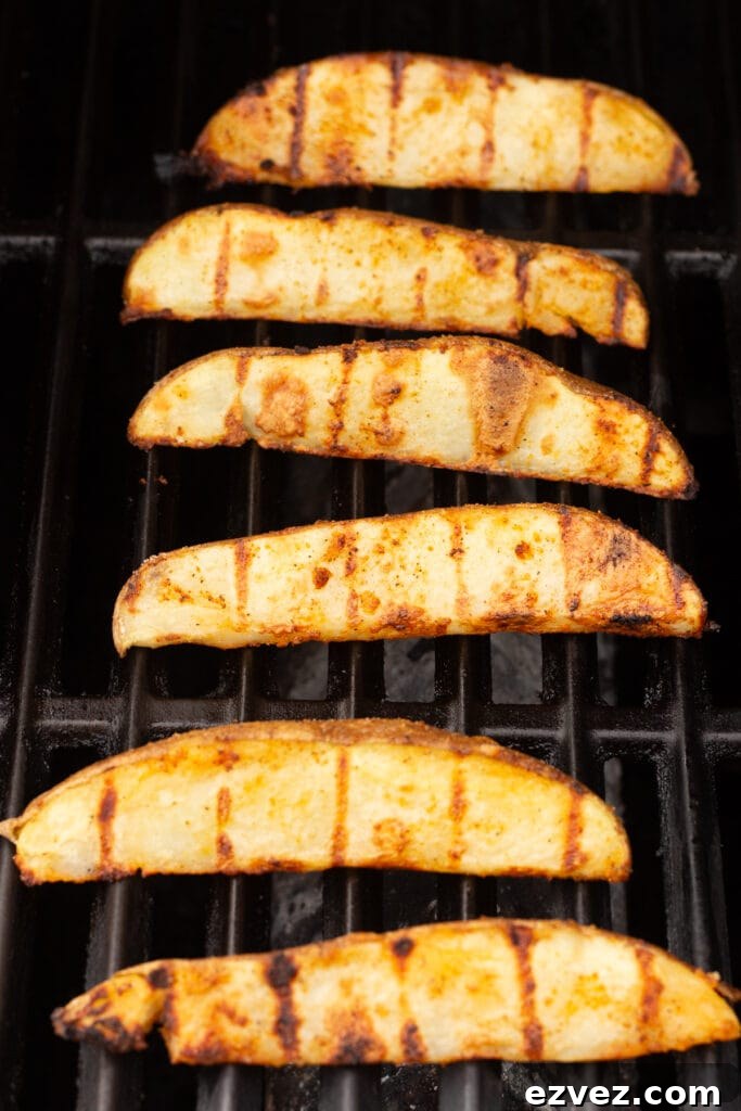 russet potato wedges being cooked on a grill.