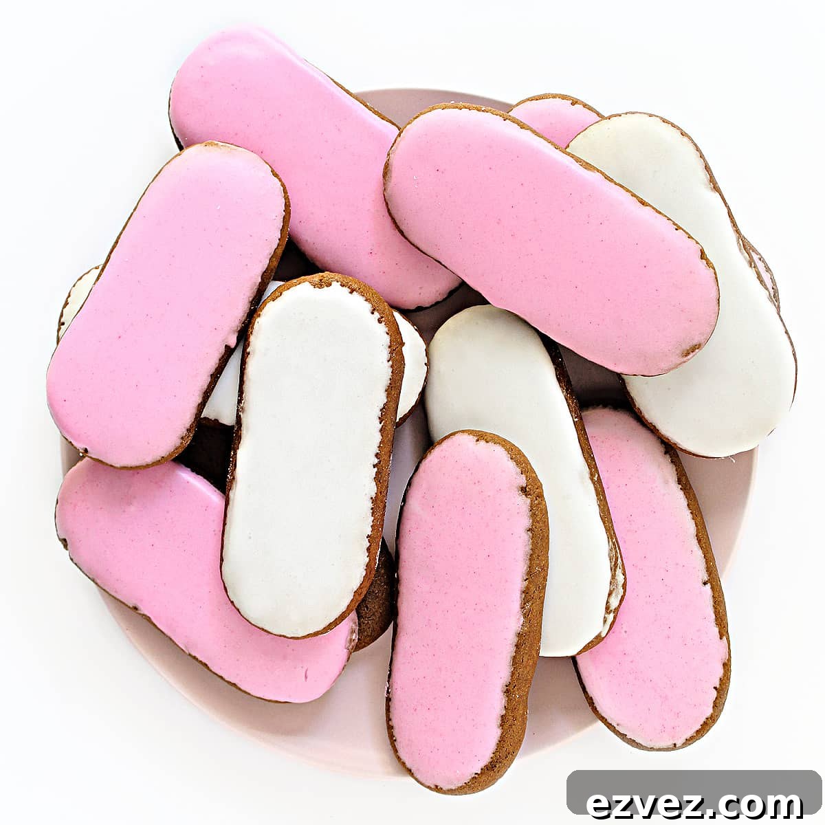 Irresistible Honey Jumbles Cookies Recipe for Crispy, Sweet Bites 7 Overhead image of oval pink and white iced cookies on a serving plate.