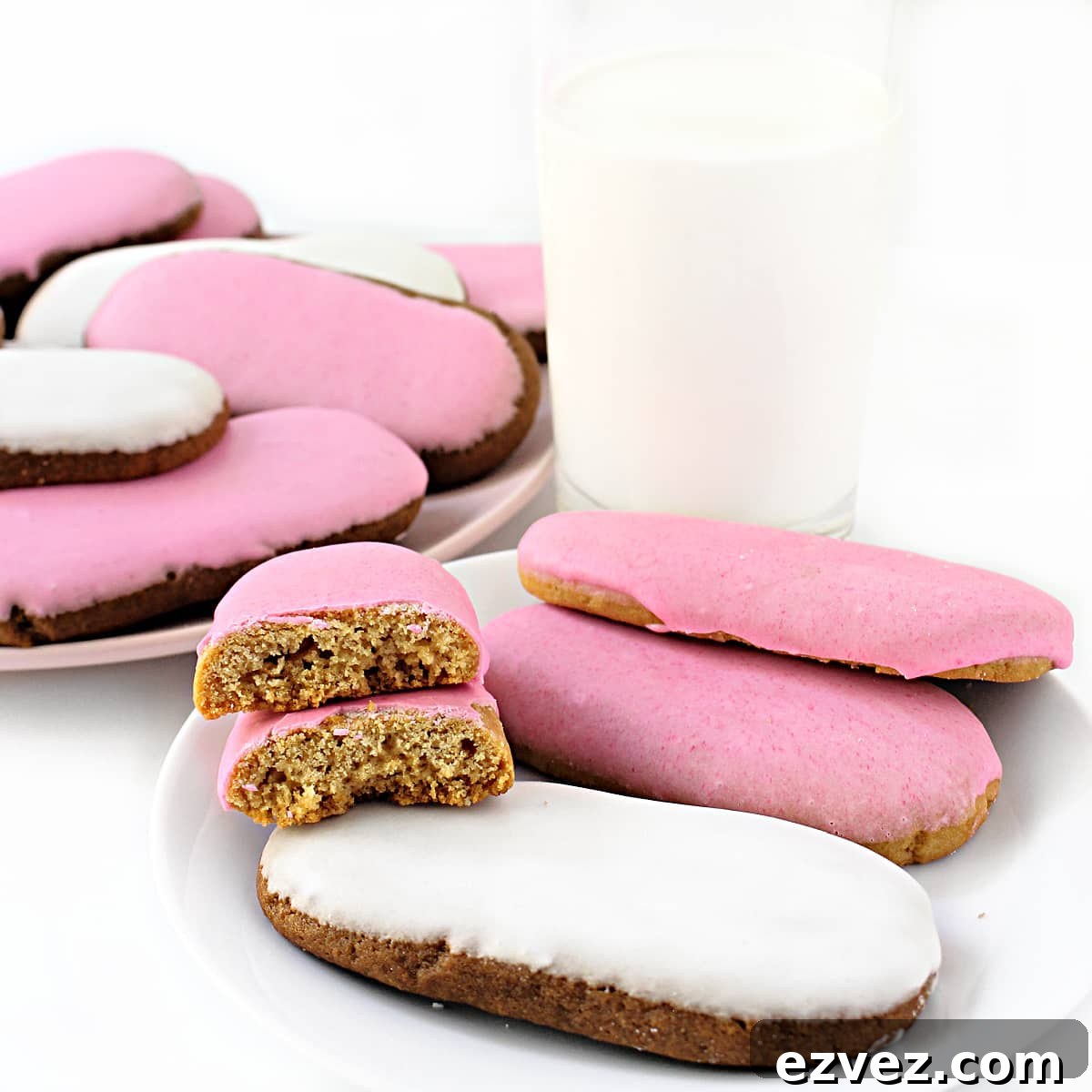 Irresistible Honey Jumbles Cookies Recipe for Crispy, Sweet Bites 8 Pink and white iced cookies on plates with a glass of milk.