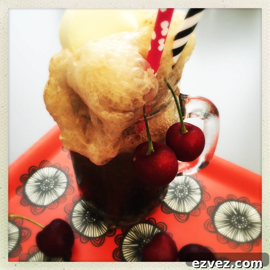 cherry coke float in a kilner jar mug with red and white spotty paper straw