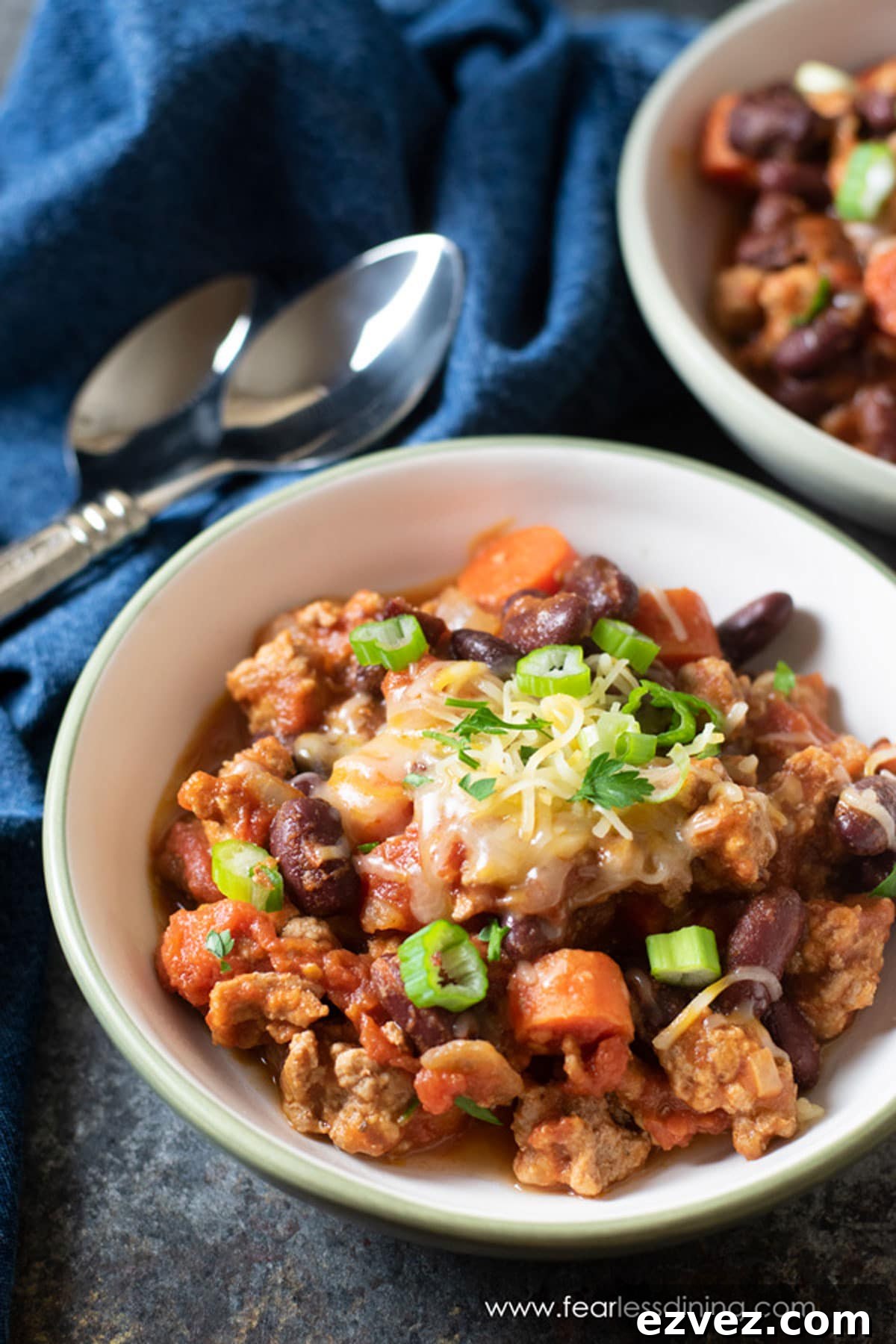 Fire-Roasting Hatch Chiles: Step-by-Step Guide + 12 Delicious Recipes 6 Two bowls full of ground pork chili topped with cheese and scallions.