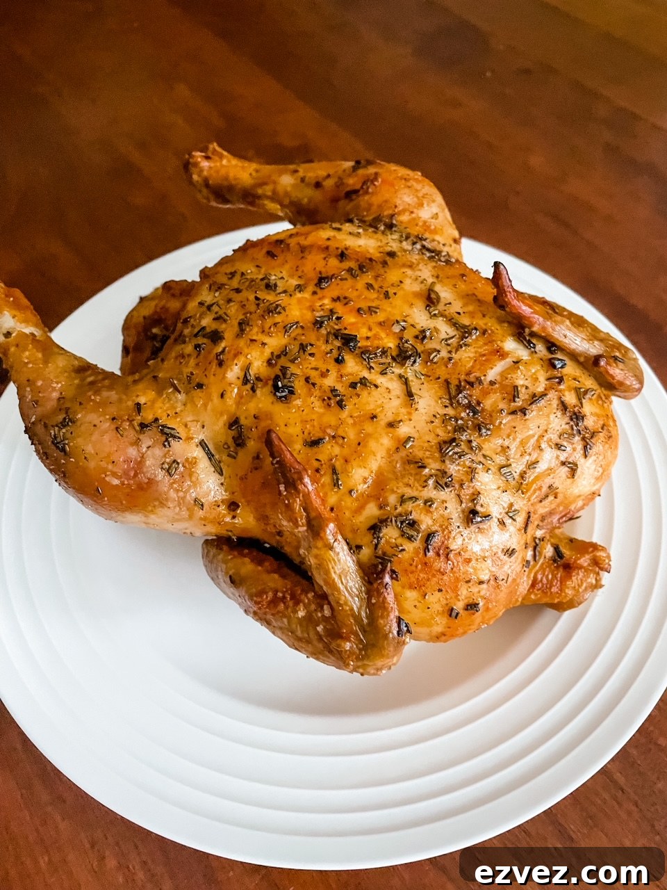 The finished Basic Herb-Roasted Chicken resting on a white plate