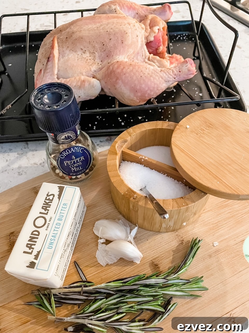 The ingredients for the Basic Herb-Roasted Chicken laid out on a wooden cutting board.