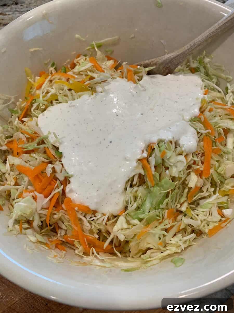 Shredded cole slaw and carrots with dressing on top.