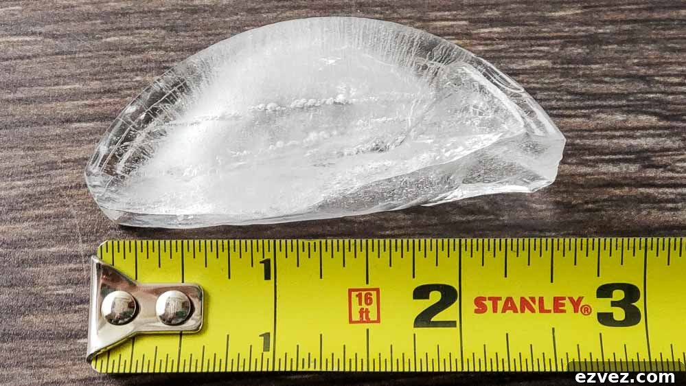 a 2 1/2 inch crescent shaped ice cube and measuring tape.