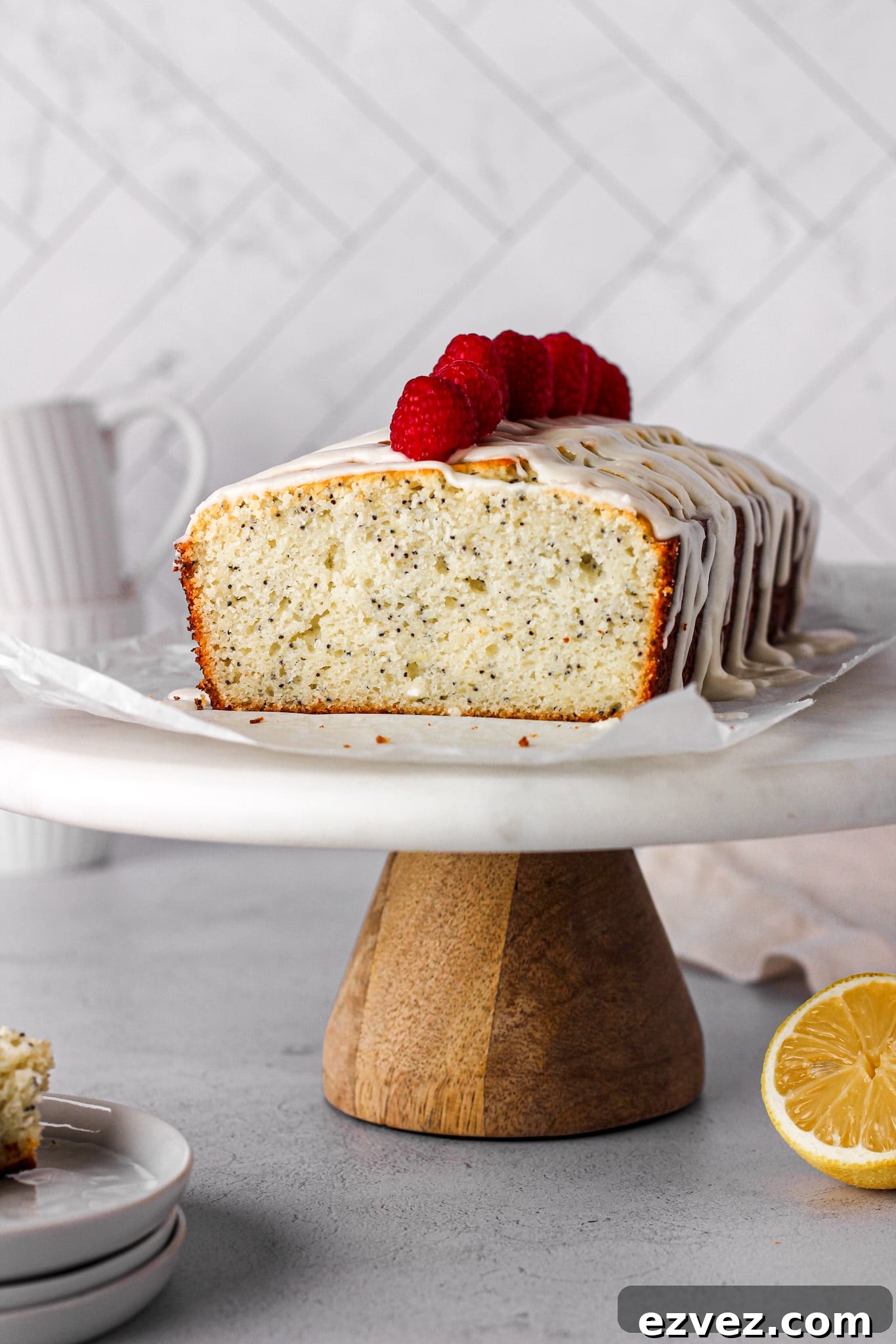 lemon pound cake with raspberries on a marble cake stand for baking blog and food photography