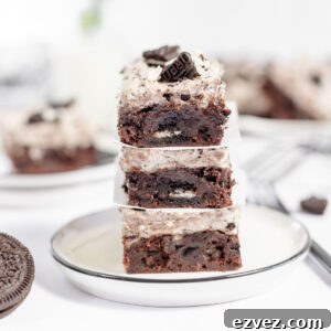 Cookies & Cream Brownies Recipe — Fudgy Oreo-Stuffed Brownies 18 Cookies and cream brownies stacked on a white plate.