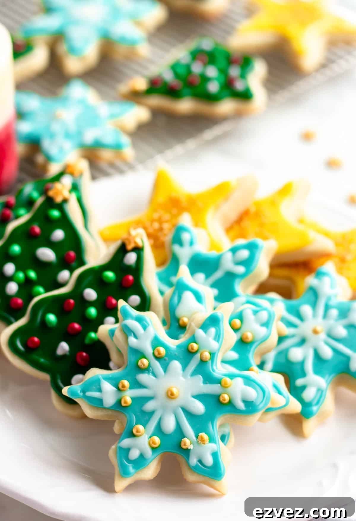 blue snowflake cookies and more vegan sugar cookies in the background on cooling rack