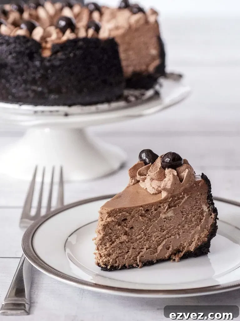 Mocha Cheesecake (6-Inch) — Rich Coffee Chocolate Dessert 5 A slice of mocha cheesecake on a white plate in front of the remainder of the cheesecake on a cake stand.