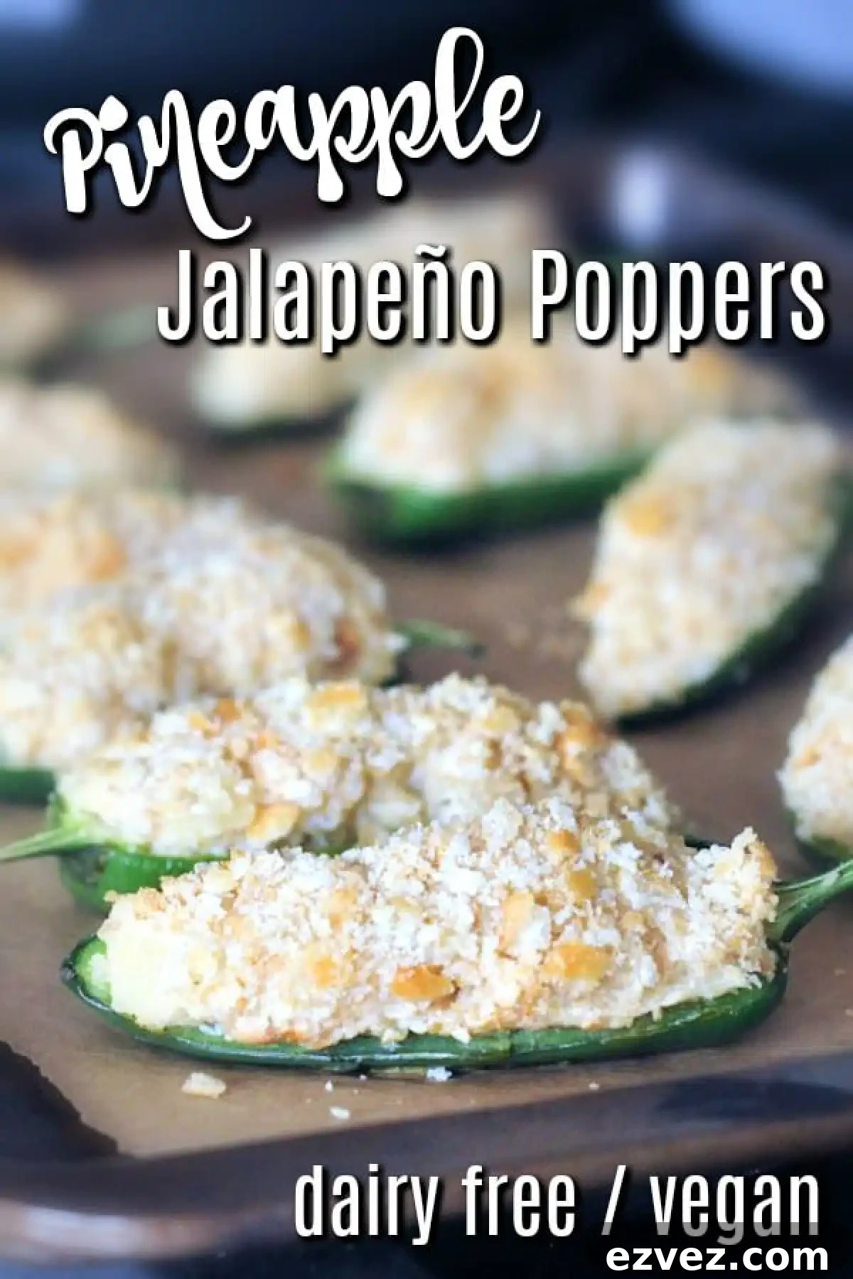 Pineapple jalapeño poppers with cracker breading on a baking sheet.