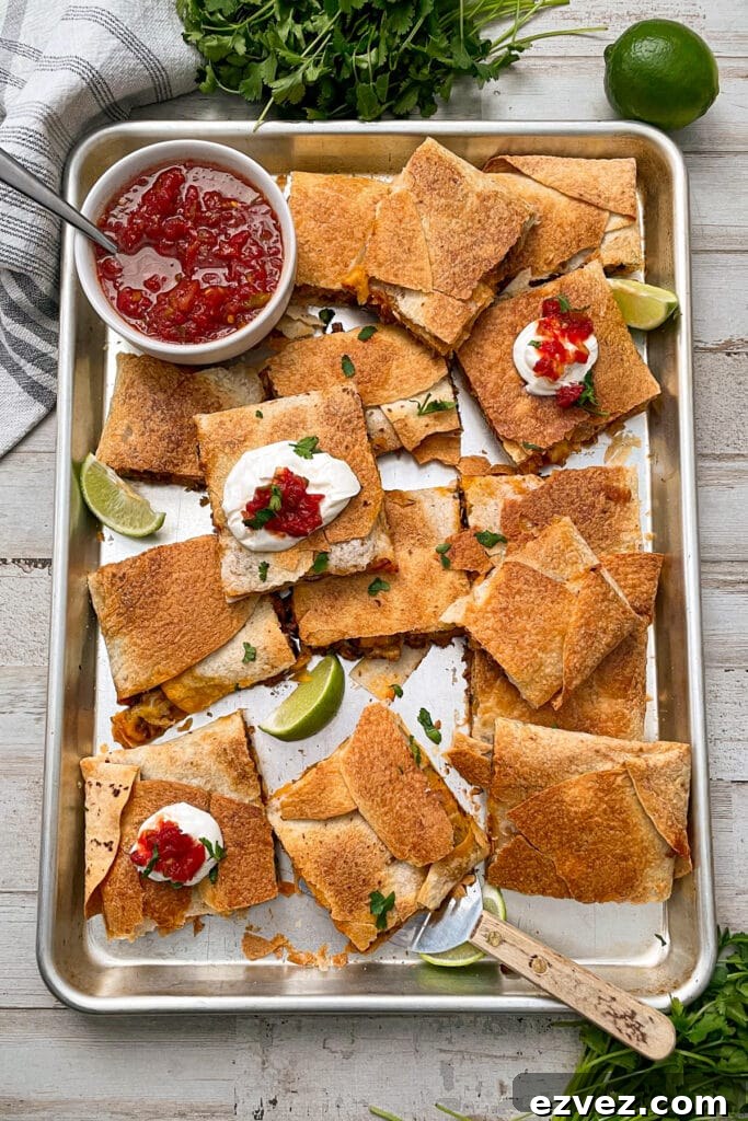 sheet pan quesadillas with ground beef served with limes and salsa