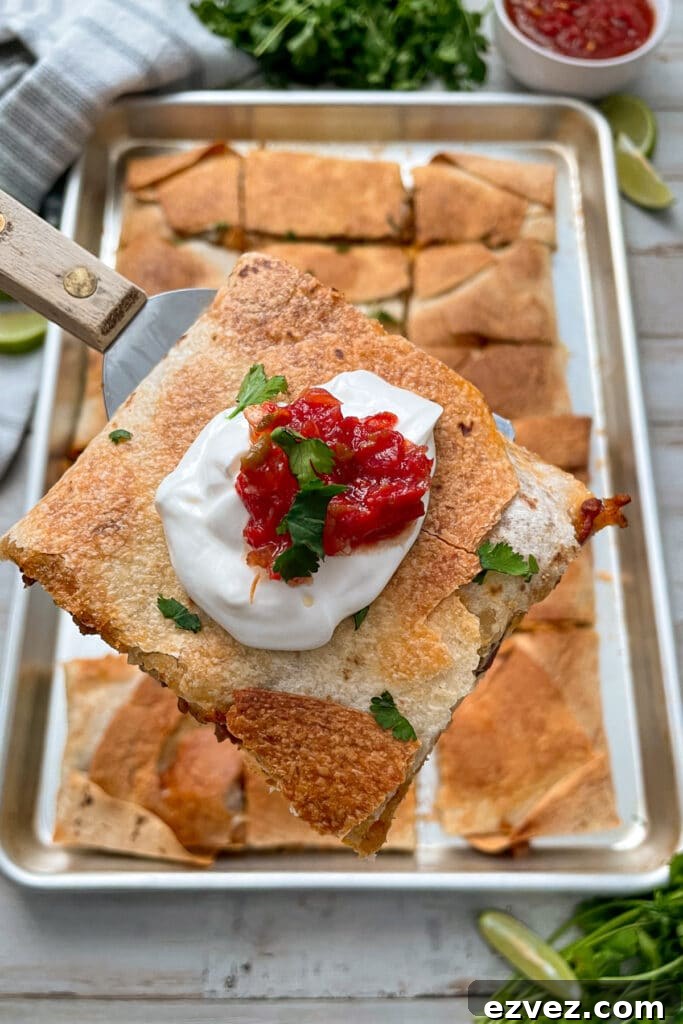 sheet pan quesadillas with ground beef served with limes and salsa