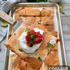 close up shot of sheet pan quesadillas topped with sour cream and salsa