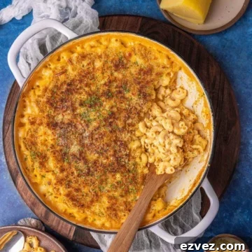 gouda mac and cheese on a flat surface garnished with breadcrumbs and herbs.