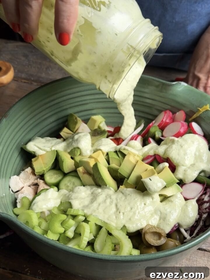 a photo of dressing pouring over sunday summer salad