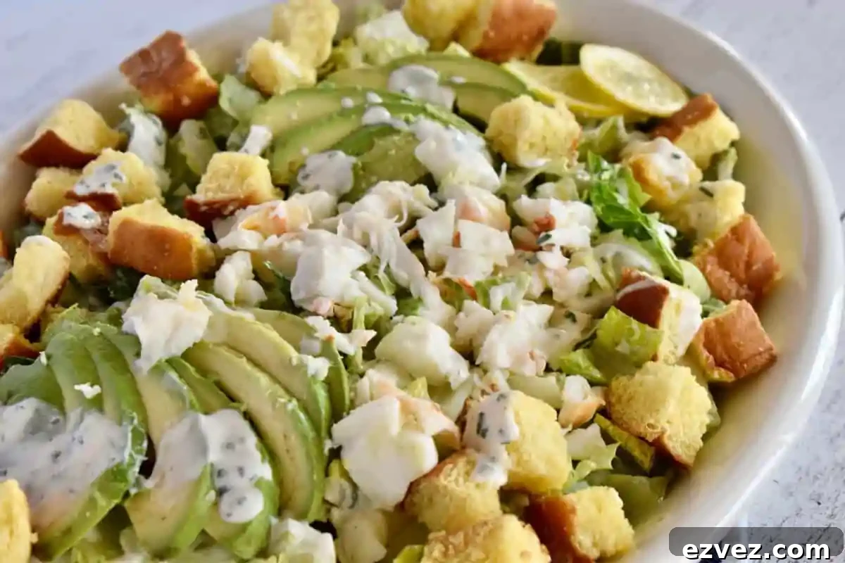 Lobster Roll Salad with brioche croutons in a large white serving dish. 