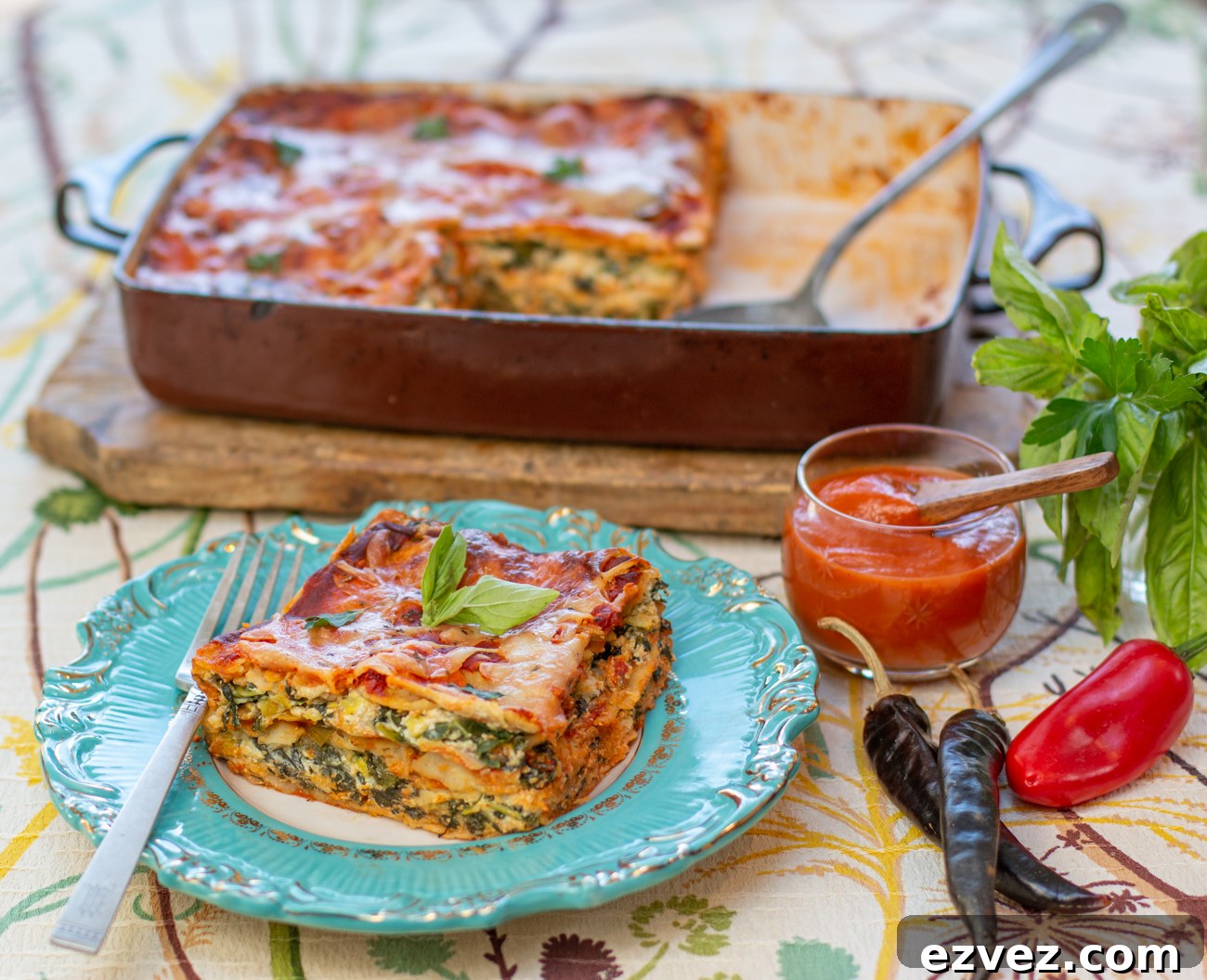 A wedge of Corn Tortilla Lasagne with Green Veggies and Roasted Red Pepper Chili Sauce