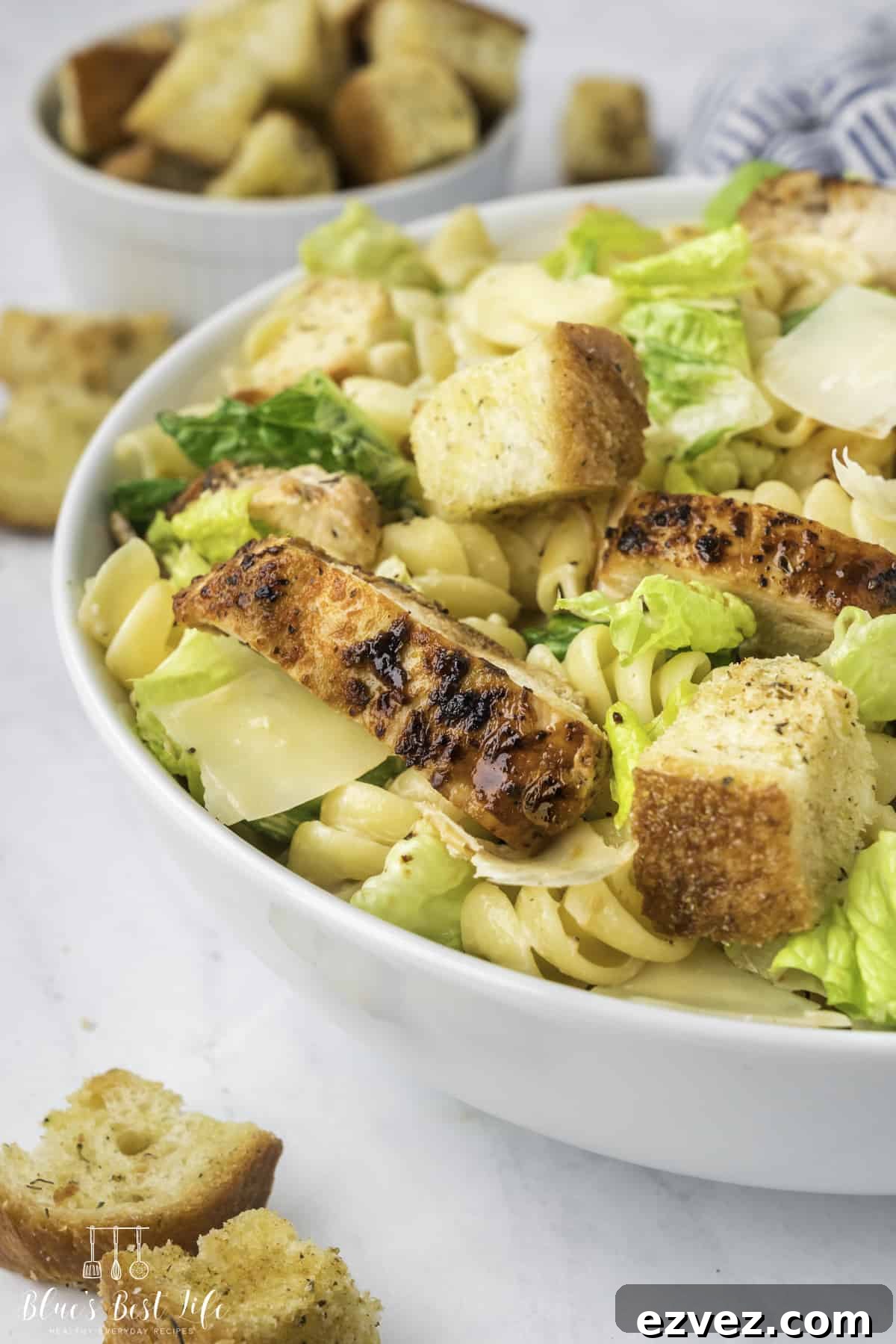 A close-up shot of Chicken Caesar Pasta Salad served in a bowl. 