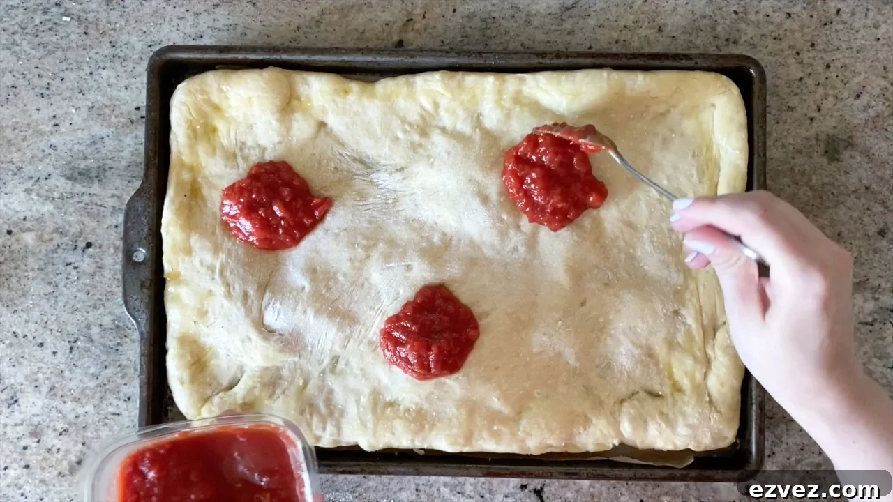 adding toppings to pizza dough