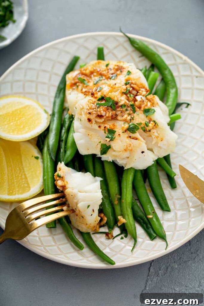 Flaky piece of fish pulled from a fillet with a fork