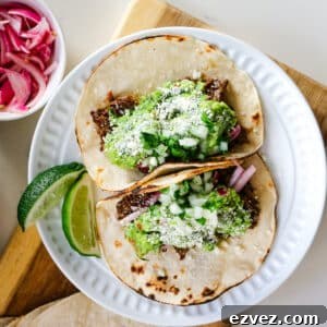 Slow-Cooker Shredded Beef Tacos for Flavorful Weeknight Meals 10 Roast tacos on a white plate with lime slices.